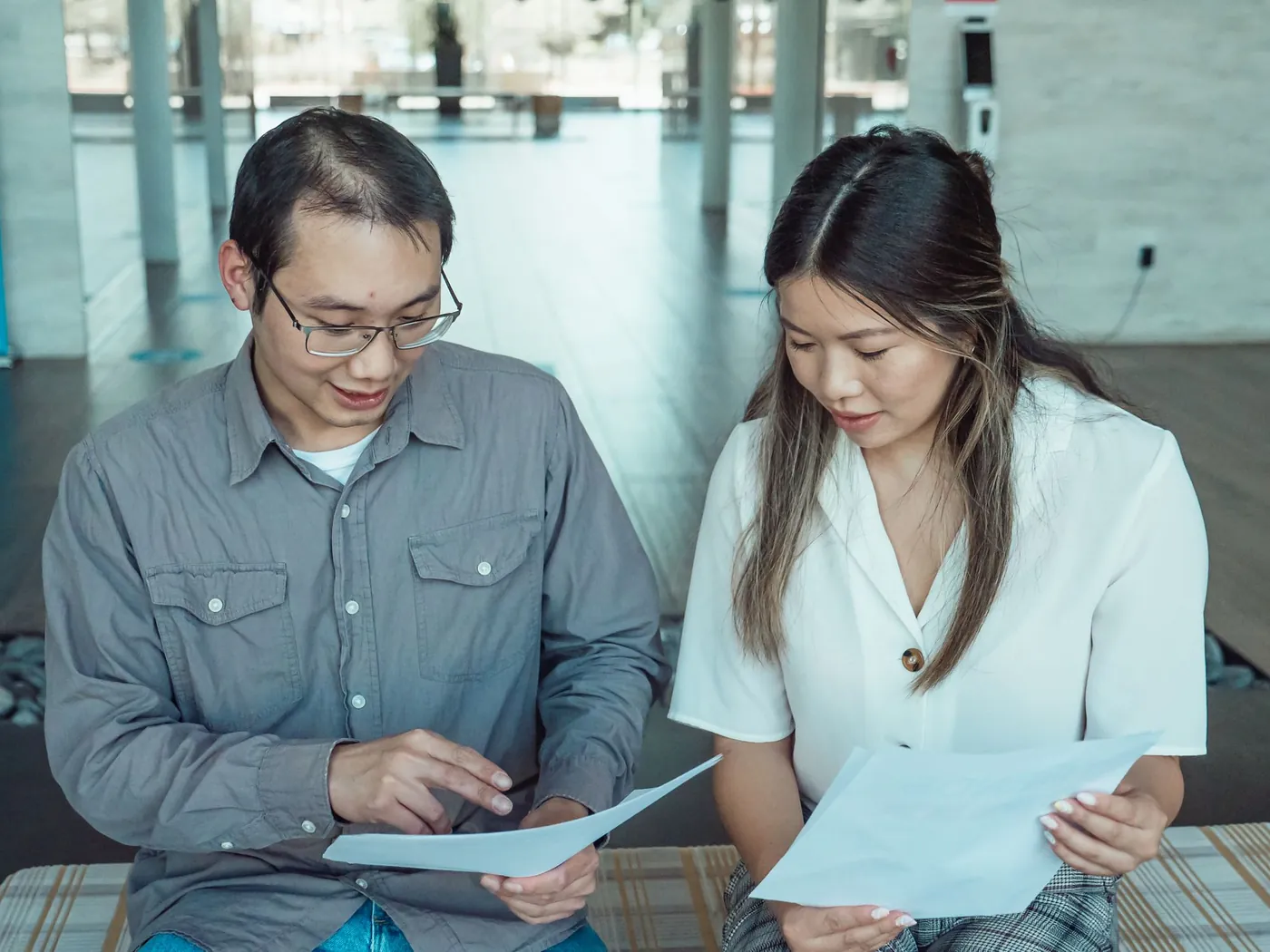 Two colleagues reviewing printed documents together
