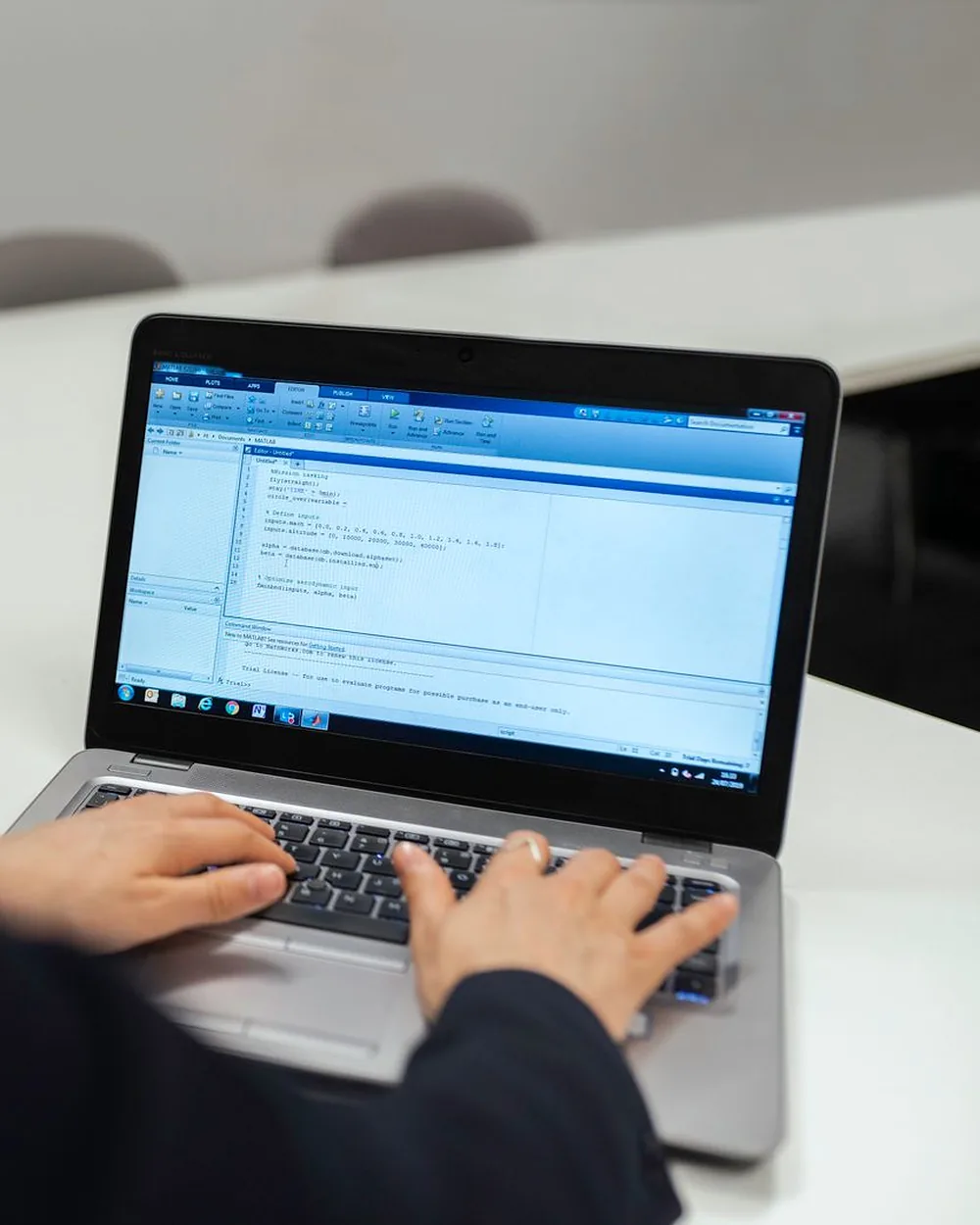 A developer focused on code at a laptop in a bright office